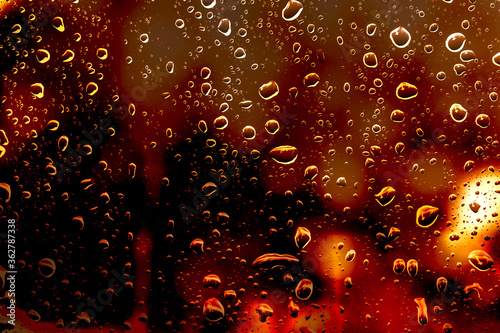water drops on glass window with bokeh lights 
