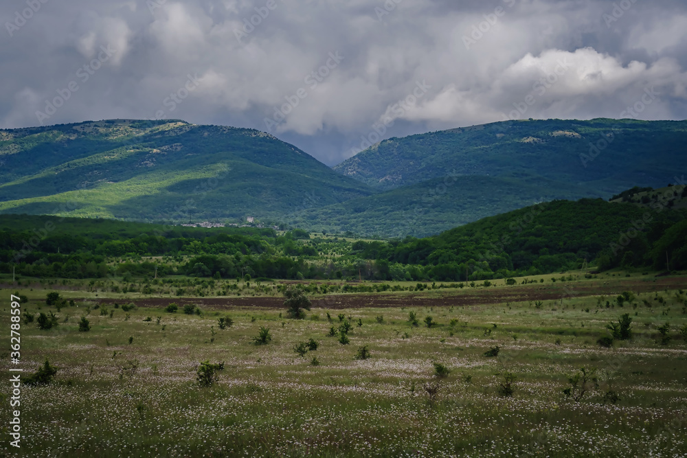 Picturesque green valley among the mountains before a storm.
