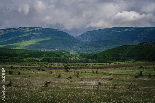 Picturesque green valley among the mountains before a storm.