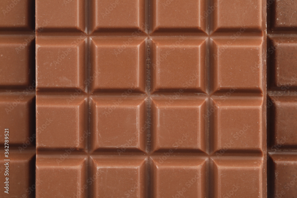 Delicious milk chocolate as background, closeup view Delicious milk chocolate as background, closeup view