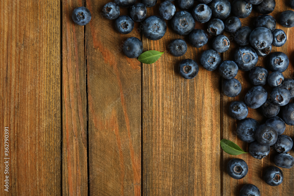 Fresh ripe blueberries on wooden table, flat lay. Space for text Fresh ripe blueberries on wooden table, flat lay. Space for text