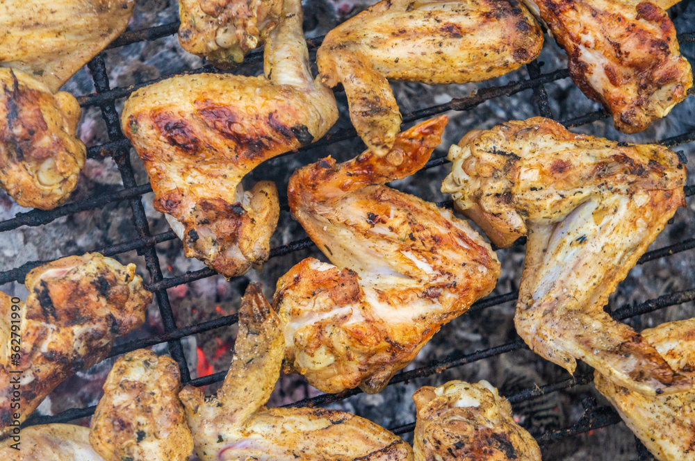 Barbecue chicken fried wings. On coals and grill close-up