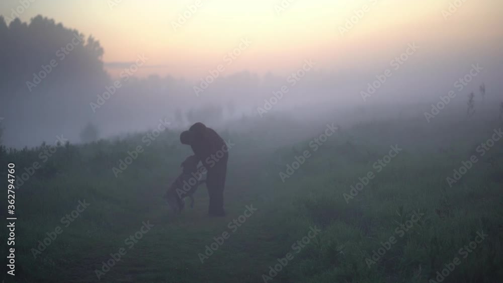 Man playing with his beautiful golden retriever dog near the fogged river. Man playing with his beautiful golden retriever dog near the fogged river.