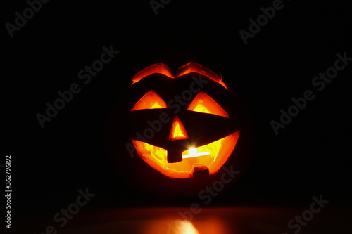Halloween pumpkin lantern jack with a candle inside. Darkness around.