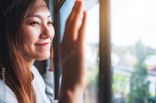 Closeup image of a young woman touching on window while looking outside Free Download Closeup image of a young woman touching on window while looking outside - GFXLoad