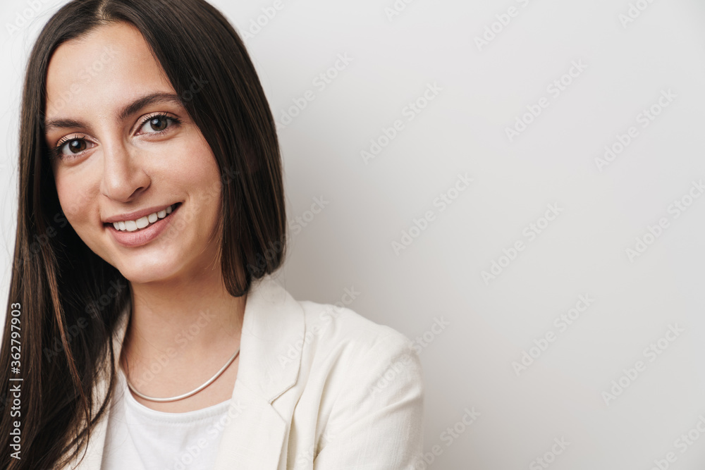 Photo of young pleased businesswoman smiling and looking at camera Photo of young pleased businesswoman smiling and looking at camera