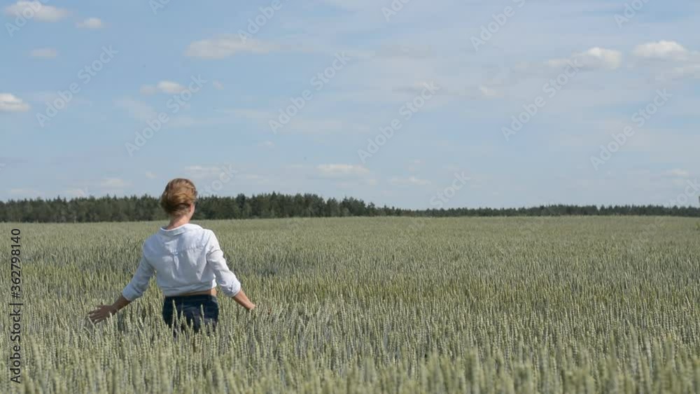 Young stylish girl walks on a wheat field on a summer sunny day, free concept Young stylish girl walks on a wheat field on a summer sunny day, free concept