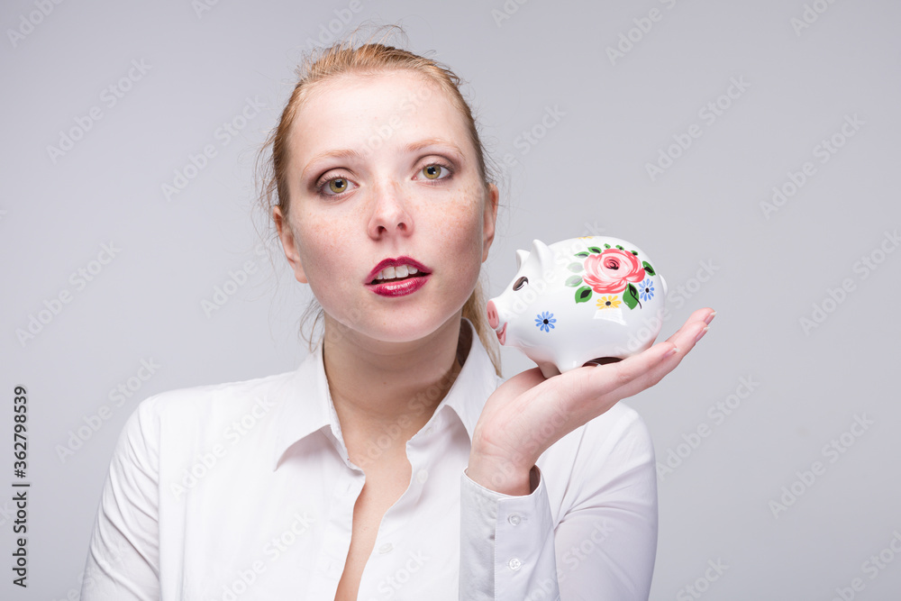 young red haired woman with her porcelain bank young red haired woman with her porcelain bank