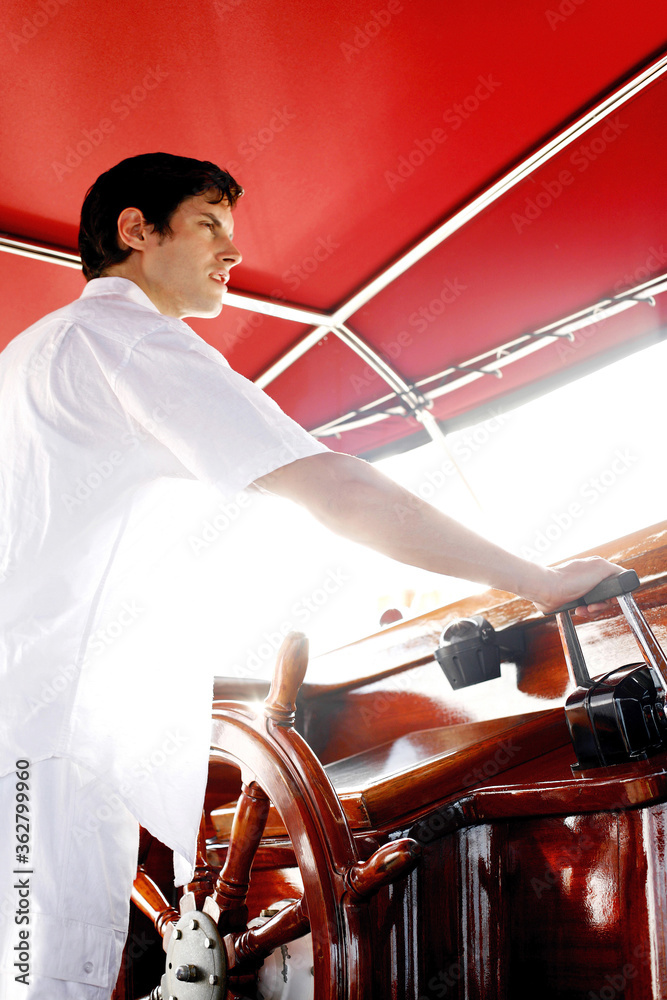 Man at helm of yacht