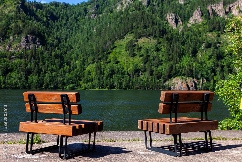 Obraz premium Two benches on the shore