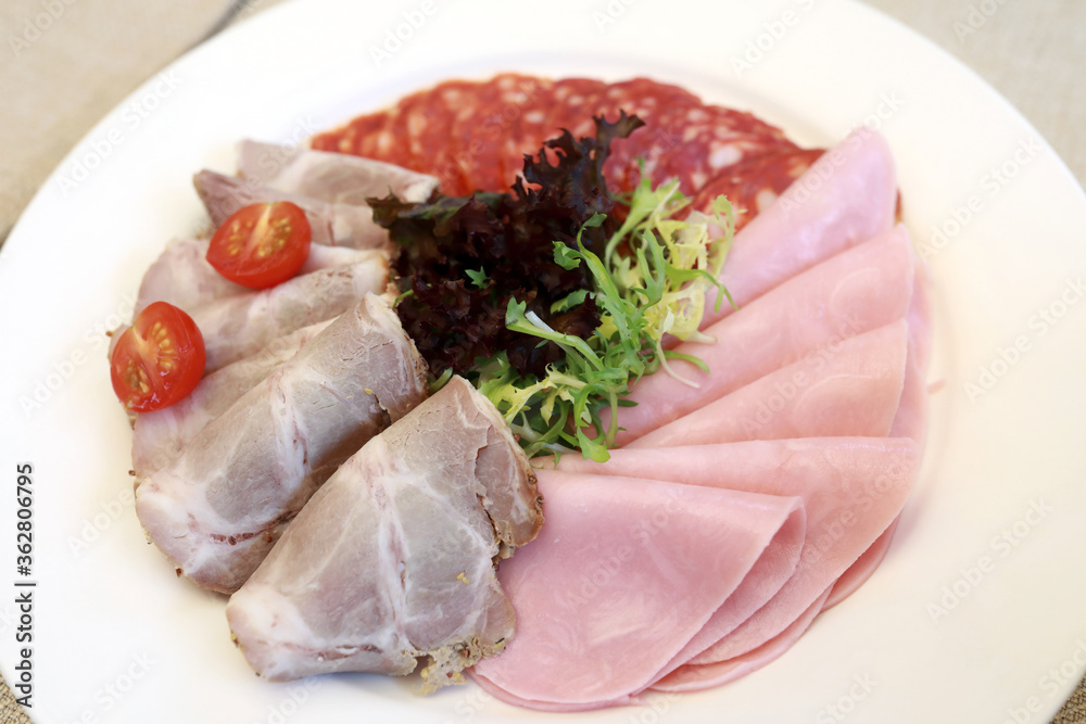 Slices various meat on white plate Slices various meat on white plate