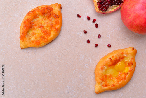 Caucasian cuisine. Georgian cuisine. Khachapuri with whole pomegranate and pomegranate seeds. Copy space. photo