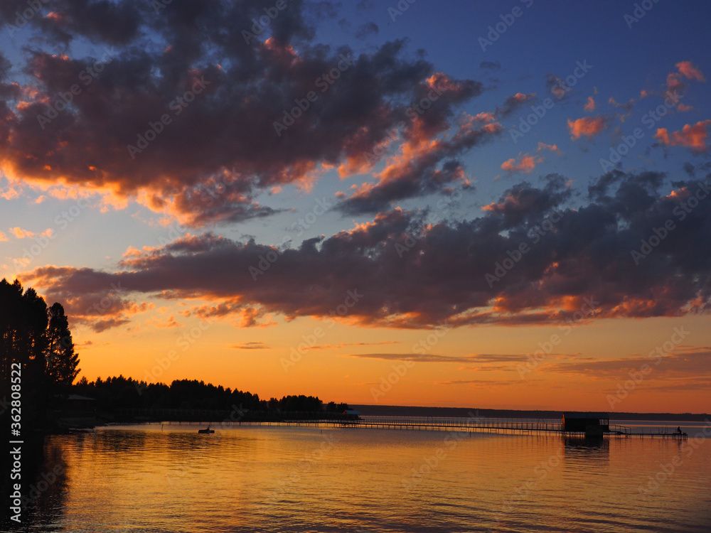 Sunset, summer, beautiful clouds at sunset. Pier on the big Kama river. Ural, Russia, Perm Territory, Elovo.