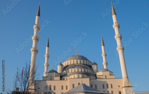 The minaret of the mosque with blue sky in the background