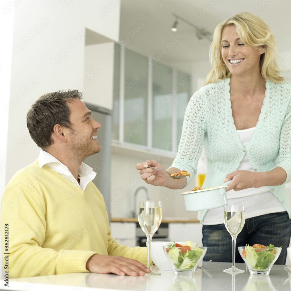 Woman serving food, man waiting at the table Woman serving food, man waiting at the table