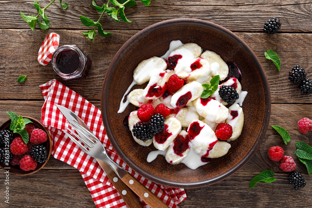 Lazy dumplings, vareniki with fresh berries. Boiled cottage cheese gnocchi with sour cream, raspberry and blackberry. Traditional ukrainian cuisine
