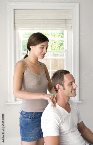 Woman massaging man's shoulders © ImageHit