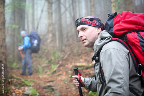 Two men hike in forest with backpack for trekking © Naz