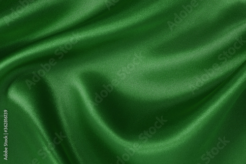 Dark green fabric cloth texture for background and design art work, beautiful crumpled pattern of silk or linen.
