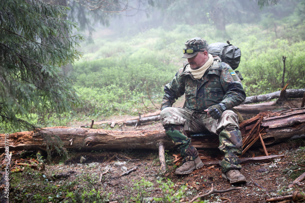 Active healthy man hiking and resting in beautiful forest