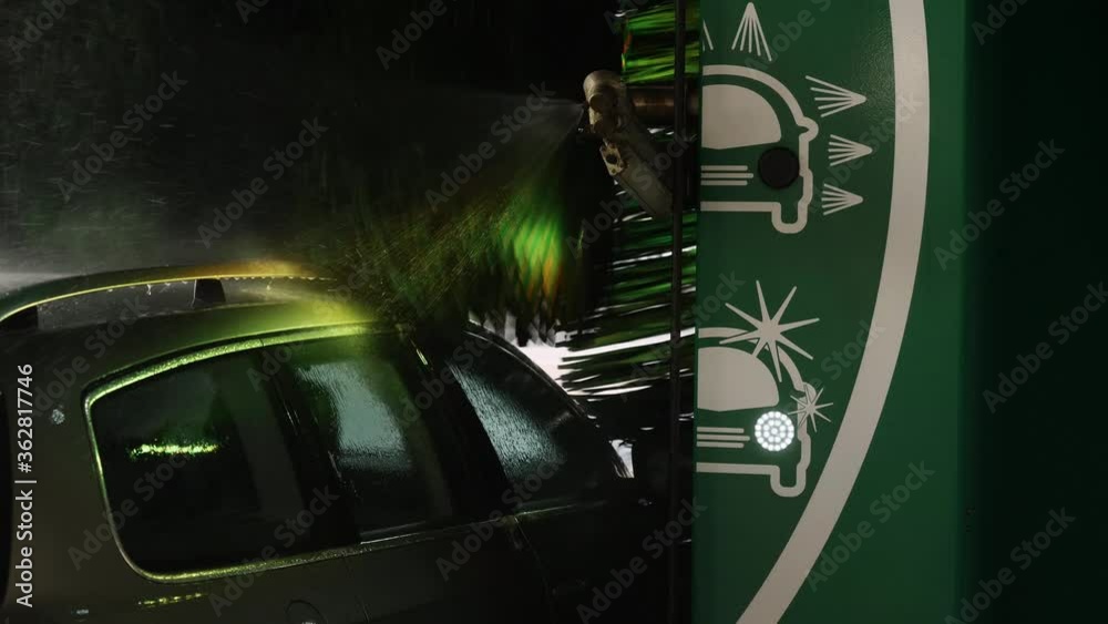 Automated car wash machine cleaning the vehicle with roof railings ...