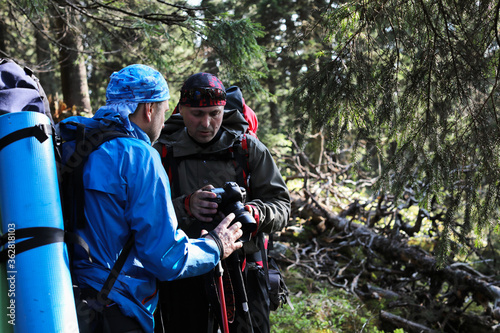 Photographer with camera on tripod shooting a landscape in forest