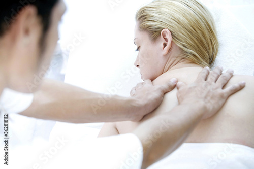 Massage therapist massaging woman's back