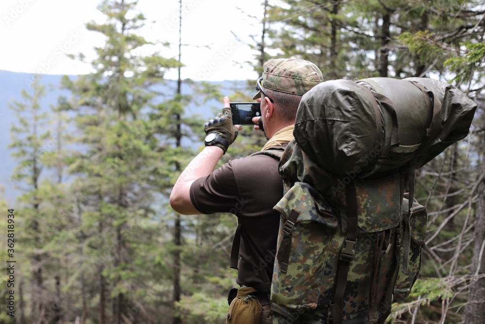 Photographer with camera on tripod shooting a landscape in forest Photographer with camera on tripod shooting a landscape in forest