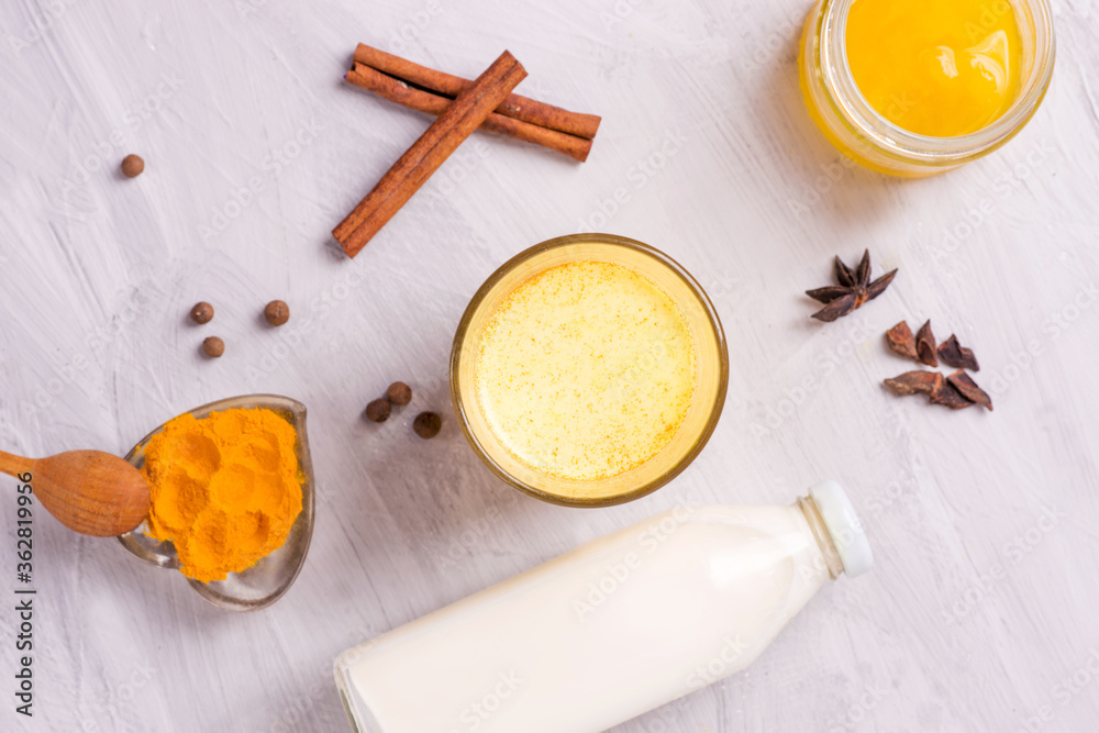 Fototapeta premium moon milk with turmeric, yellow Vedic milk with spices, honey, cinnamon, anise and pepper, vegan food