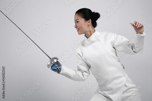 Woman in fencing suit with fencing foil