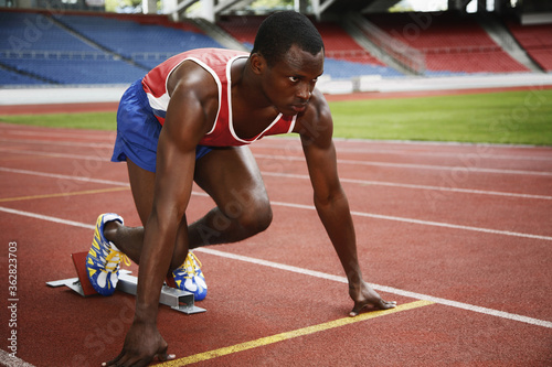 Man in starting position on running track © ImageHit