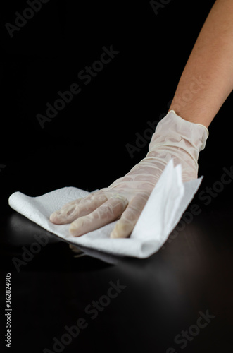 mano con guante limpiando mesa 