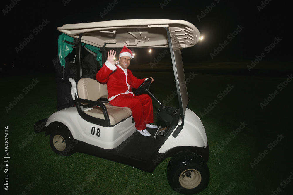 Man in Santa suit driving a golf cart