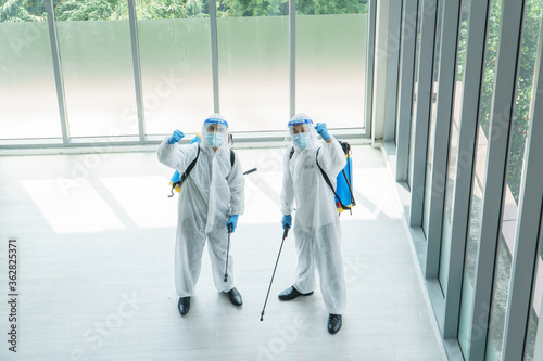 Men in protective clothing sprayed to disinfect contaminated areas
