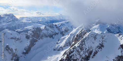 Misty panoramic view of the high mountains covered by clouds in the Dolomites Alps in Italy. © thecolorpixels