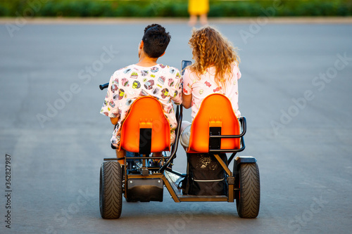 A young couple rides a tricycle © Lensplayer