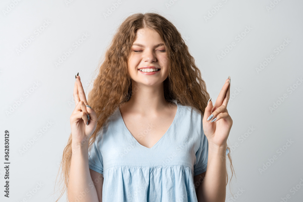 I have to win. Joyful European young woman with curly long hair raises fingers crossed, makes desirable wish, wears casual clothes, waits for good news. I have to win. Joyful European young woman with curly long hair raises fingers crossed, makes desirable wish, wears casual clothes, waits for good news.