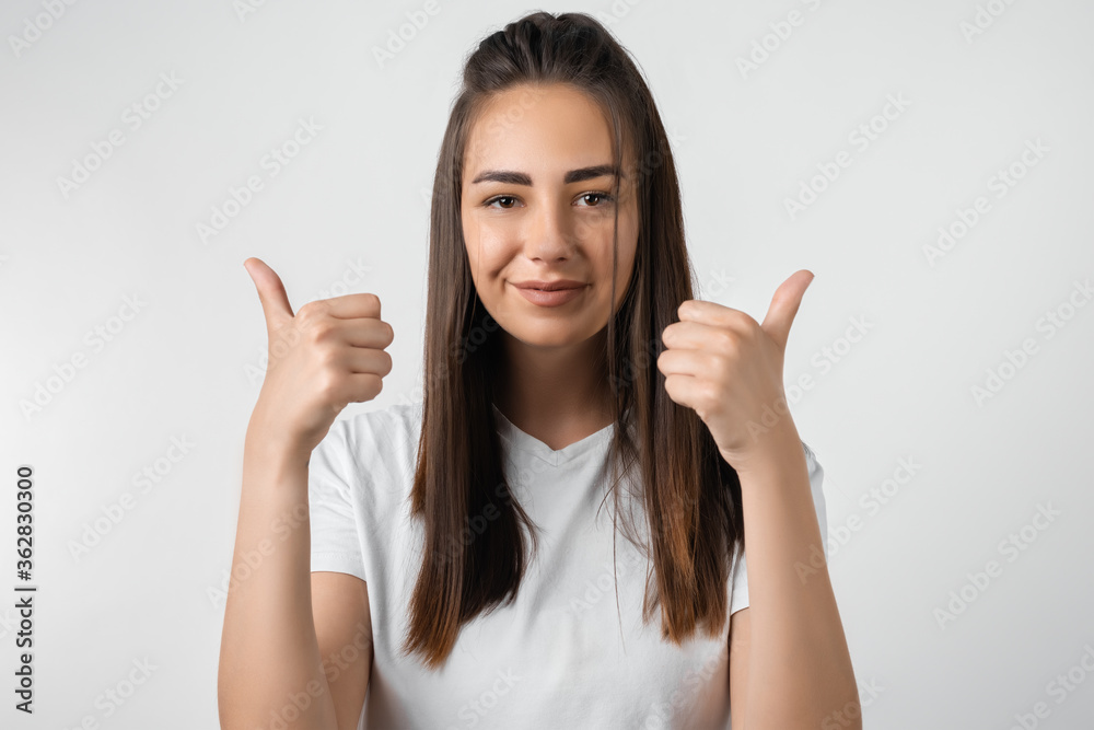Good job! Pretty carefree modern stylish European girl with long chestnut hair making OK with both hands, gesture as if saying that everything is finee, white background Good job! Pretty carefree modern stylish European girl with long chestnut hair making OK with both hands, gesture as if saying that everything is finee, white background