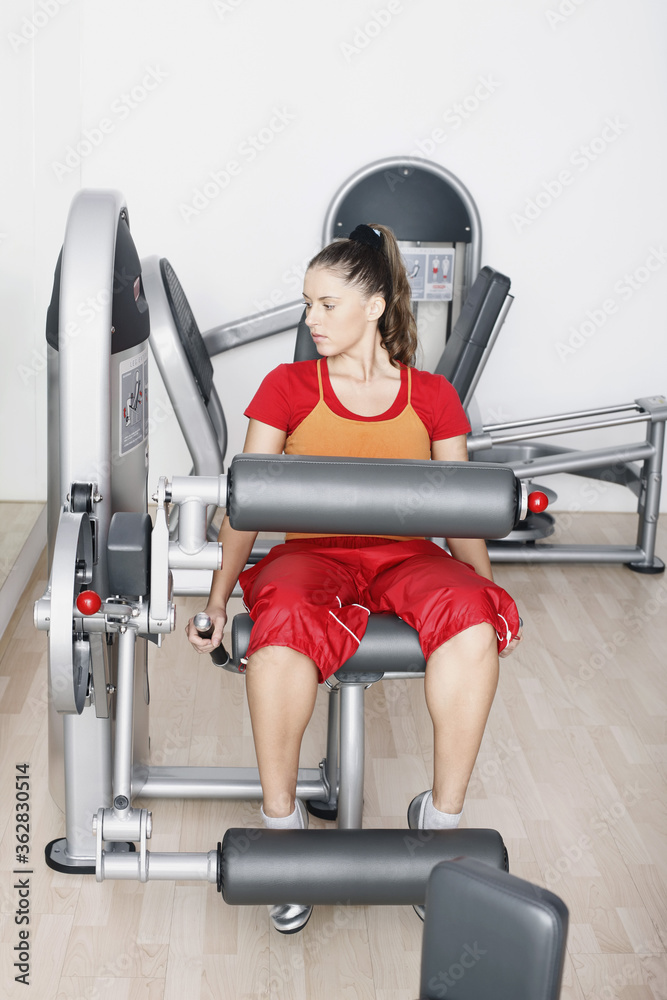 Fototapeta premium Woman exercising on gym equipment