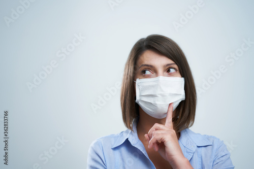 Attractive woman wearing protective mask isolated over white background