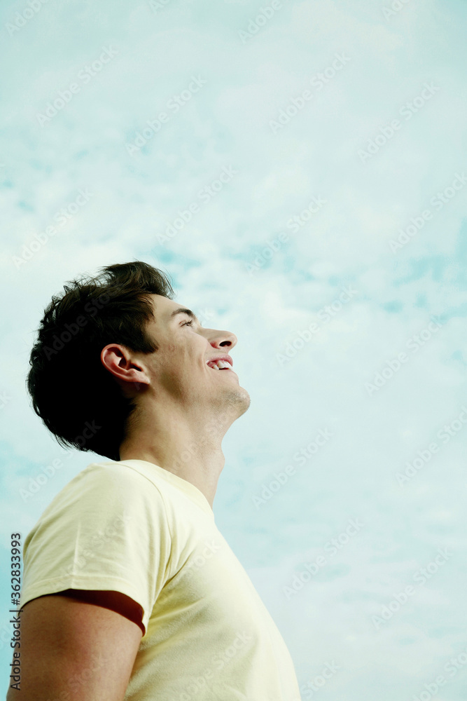 Young man laughing while looking up Young man laughing while looking up