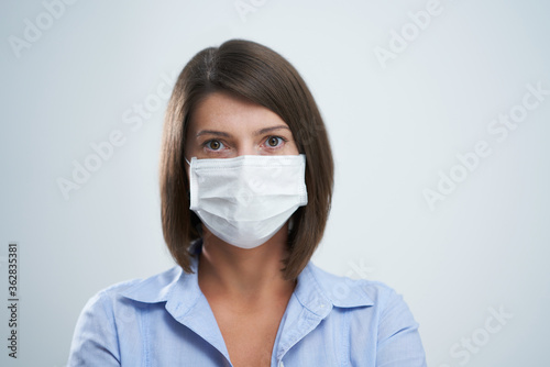 Attractive woman wearing protective mask isolated over white background