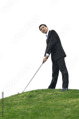 Businessman preparing to drive golf ball