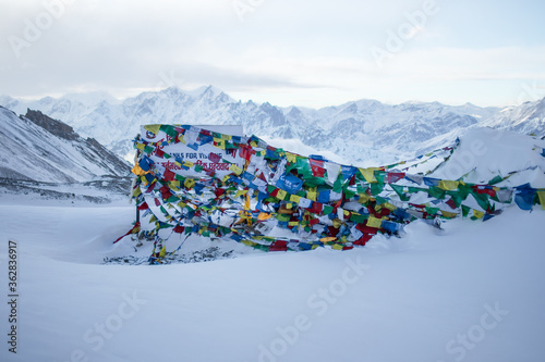 Prayer flags at Thorung La Pass summit covered in heavy snow, Annapurna circuit, Nepal photo