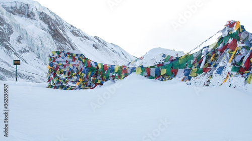 Prayer flags at Thorung La Pass summit covered in heavy snow, Annapurna circuit, Nepal photo