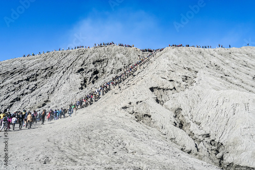 Large amount of tourists queup up to climb visit famous active volcano crater, Mount Bromo, East Java, Indonesia, July 2019