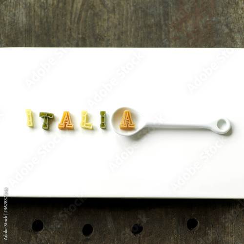 Some alphabet pasta being arranged into a word