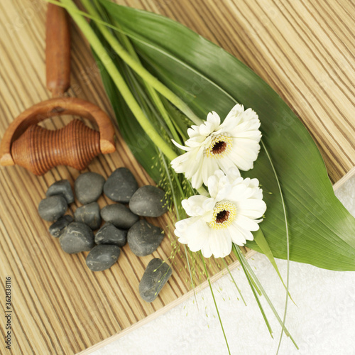 Fototapeta Naklejka Na Ścianę i Meble -  Flowers, wooden massager and small stones