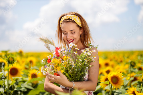 Pretty young woman on a sunflowers field