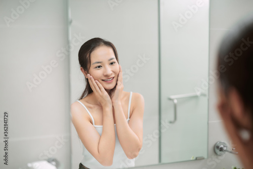 Beautiful smiling young woman with fresh skin of face posing in bathroom